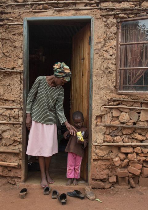 Winile stands outside her house in the Manzini region of Swaziland